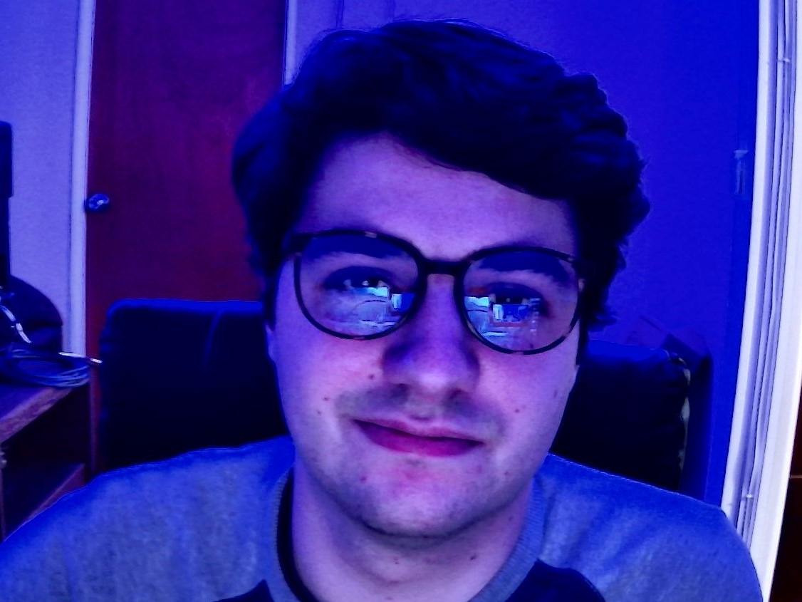 picture of zack wearing blue light glasses with purple light in the background